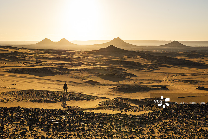 一个男人在美丽的日子里欣赏埃及非洲黑沙漠的美丽岩石 formations。图片素材