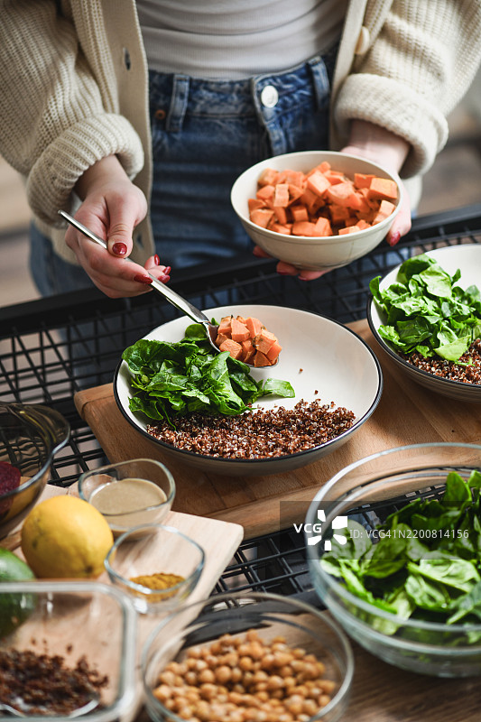 女性用色彩丰富的营养成分制作美观的佛碗图片素材