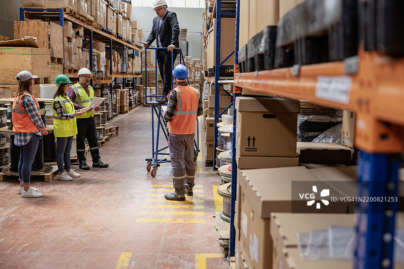 协作创新：在工厂仓库走廊中的头脑风暴和讨论图片素材