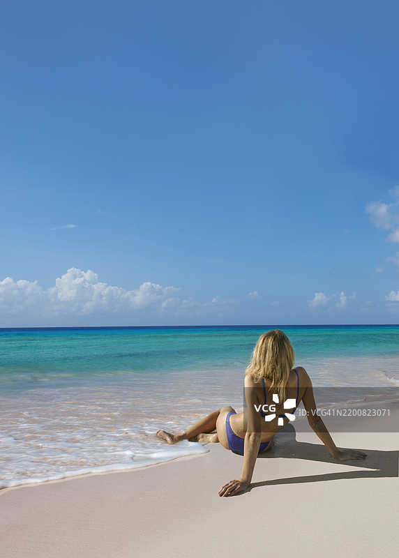 年轻女性在热带海滩上。图片素材