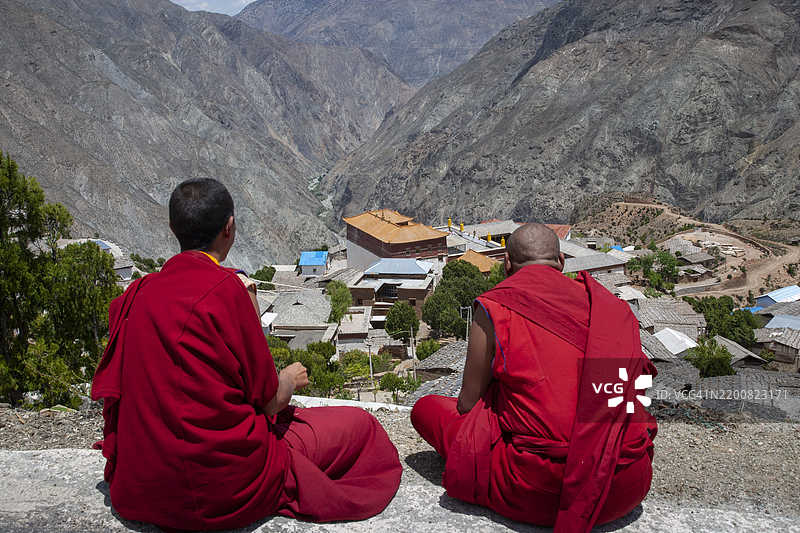 佛教僧侣在山村观看寺院。图片素材