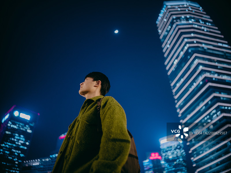 自信的亚洲男子站在明亮的上海金融区图片素材