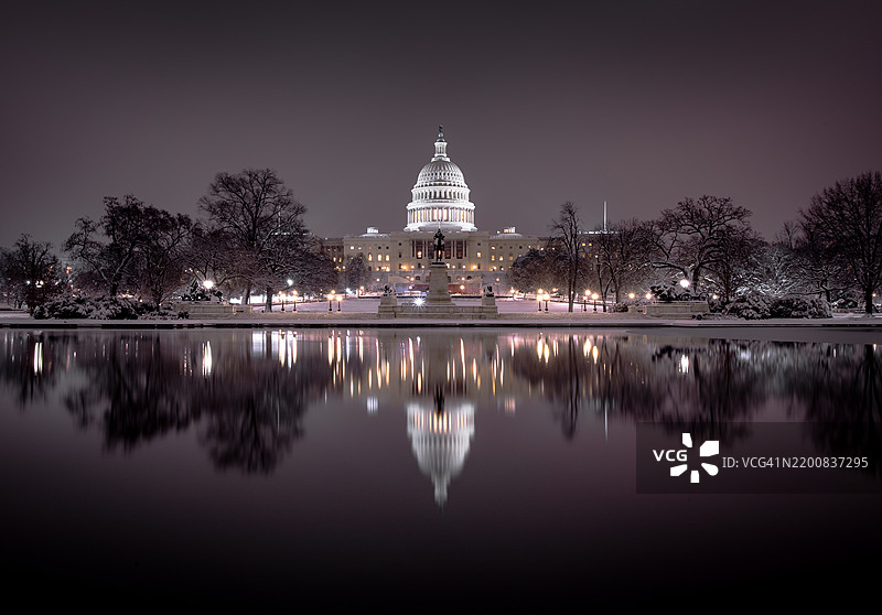 黄昏时分雪中的国会大厦倒影图片素材