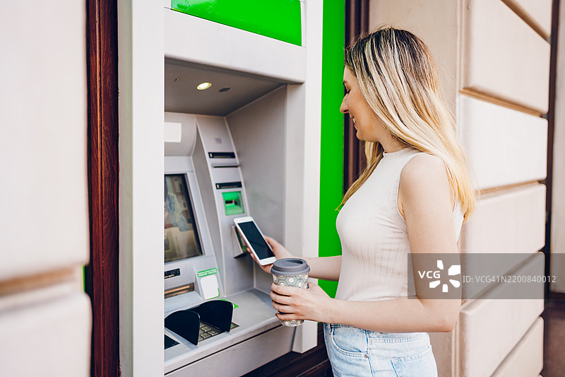 年轻女性在使用自动取款机图片素材