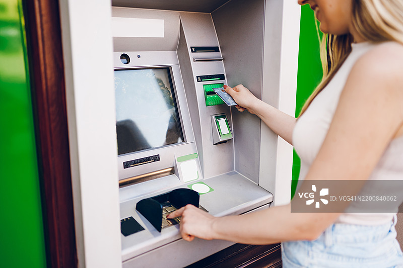年轻女性在使用自动取款机图片素材