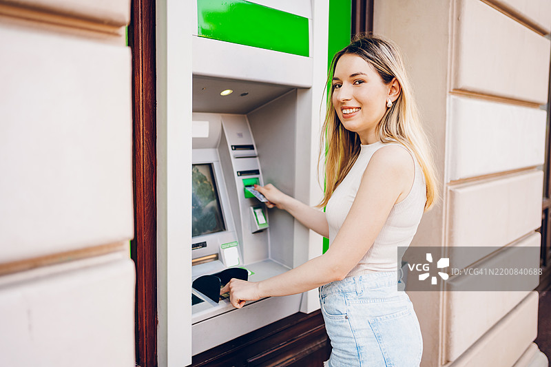 年轻女性在使用自动取款机图片素材