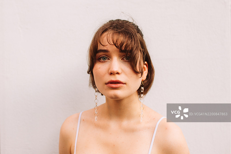 美丽年轻女性站在灰色墙壁前的肖像图片素材