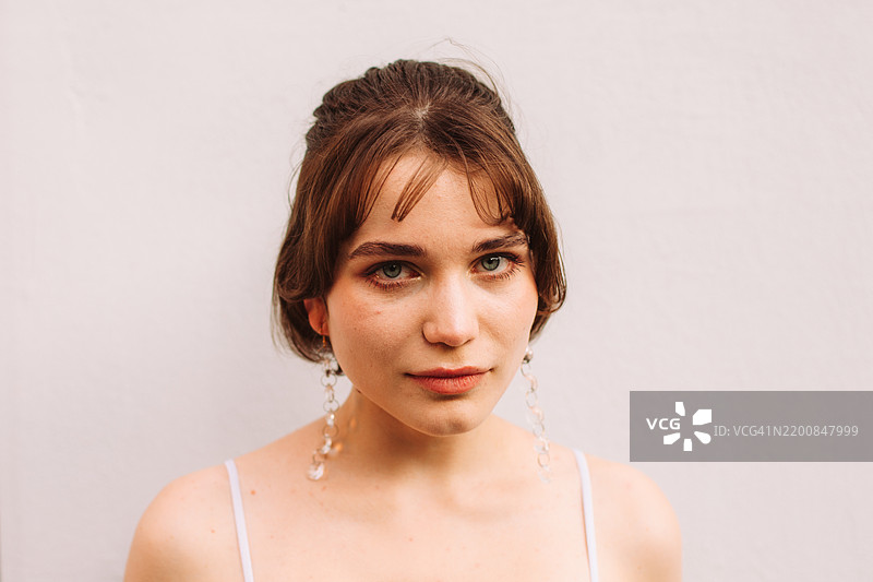 美丽年轻女性站在灰色墙壁前的肖像图片素材