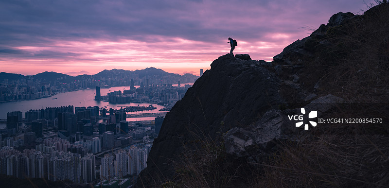 背包客在山脊上徒步旅行，俯瞰九龙峰/飞鹅山的美景图片素材