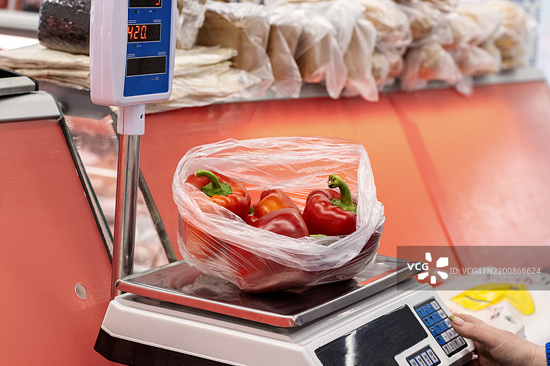 数字秤记录红椒的重量。现代农产品设备在超市收银台计算精确的分量。图片素材