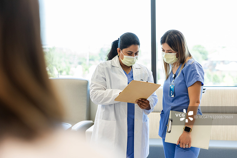 两名女性医护人员在医院讨论病人护理图片素材