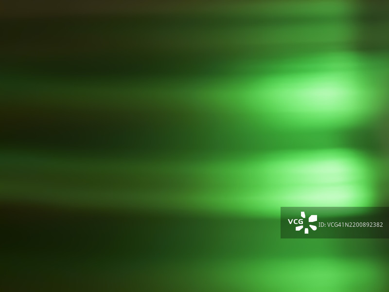 明亮的绿色光束在黑暗背景上创造出抽象效果，出现在创意艺术活动中图片素材