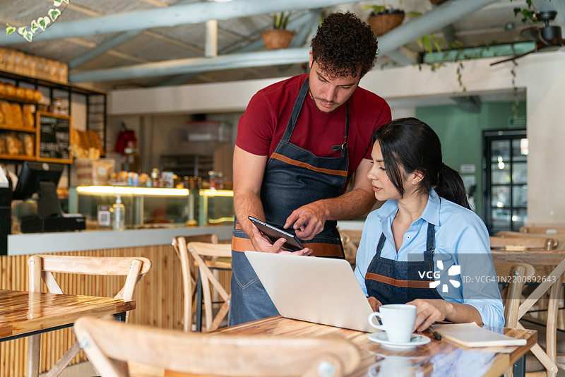 服务员与一位正在进行会计工作的商务经理交谈图片素材