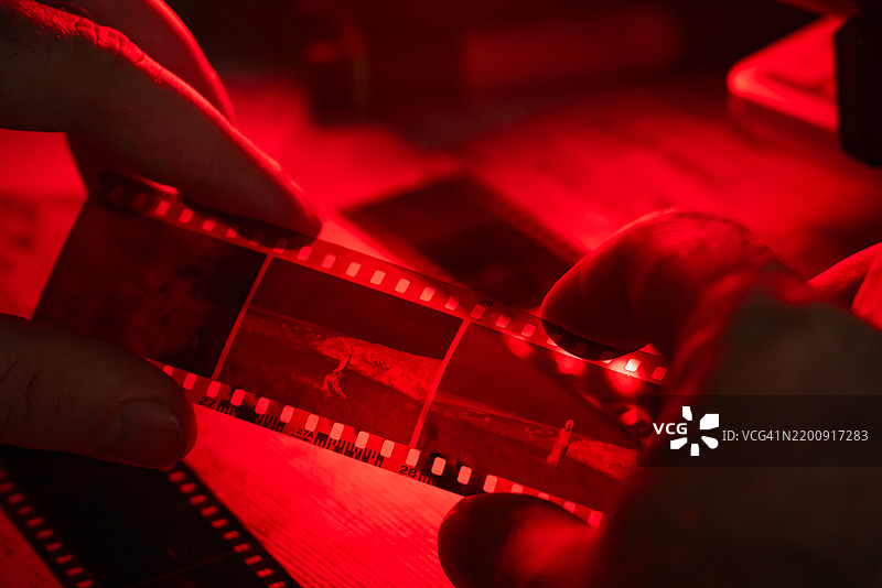男子在观察35毫米胶卷带图片素材