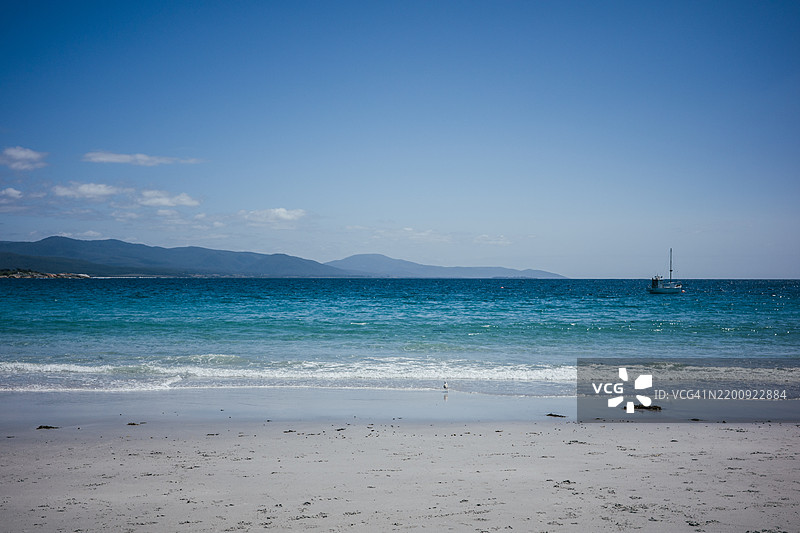 美丽的海滩景色，岸边有岩石，蓝天和清澈的海水图片素材