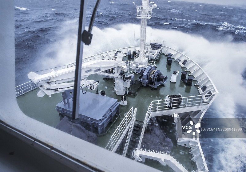 在前往南乔治亚岛的途中，海浪在暴风雨中撞击船头。图片素材