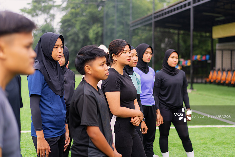 年轻多元化的女性运动员在足球训练中听教练讲解图片素材