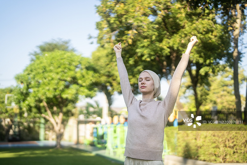 一位癌症患者在宁静的公园里优雅地伸展。图片素材