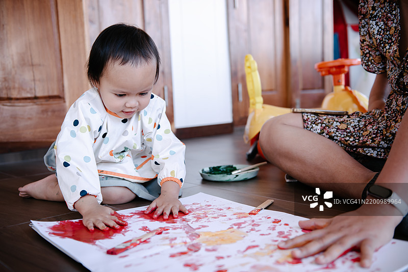 小女孩在家里和妈妈一起享受水彩手绘的乐趣图片素材