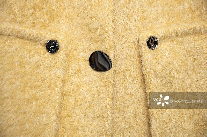 一件带有黑色石头纽扣的棕色夹克图片素材