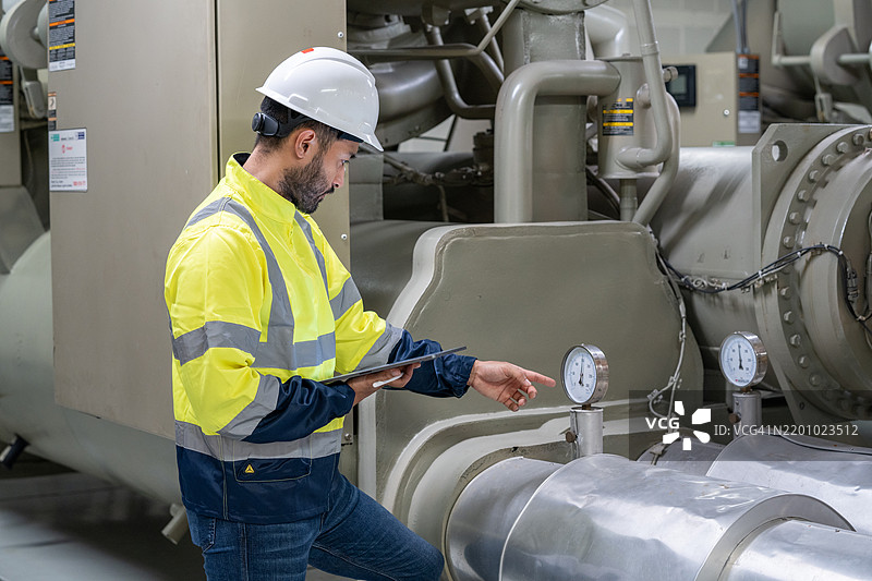 海洋工程师在机舱控制室启动或停止船舶主机。水手的工作。图片素材