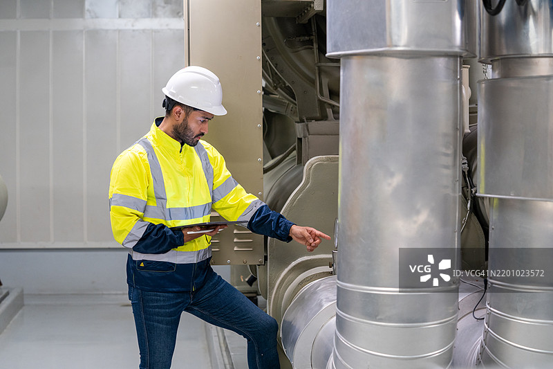 海洋工程师在机舱控制室启动或停止船舶主机。水手的工作。图片素材