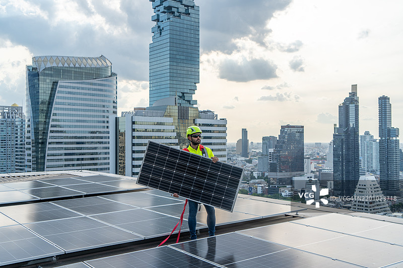 专业工程师服务太阳能电池板。工人维护清洁更换太阳能电池板。工业屋顶上的太阳能光伏电池板系统。利用清洁能源节约能源。图片素材