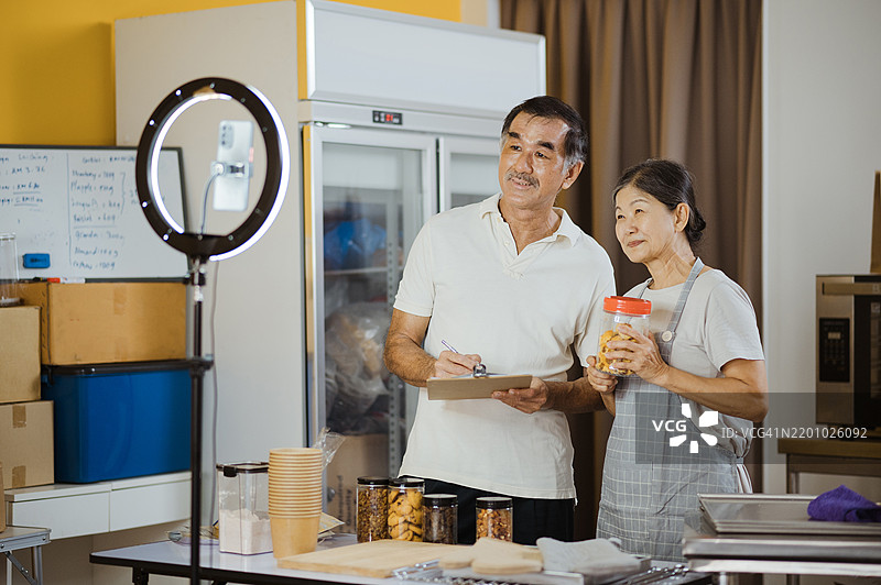 小企业主通过三脚架上的智能手机进行在线销售直播。图片素材