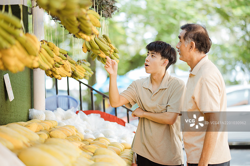 店主帮助顾客挑选水果图片素材