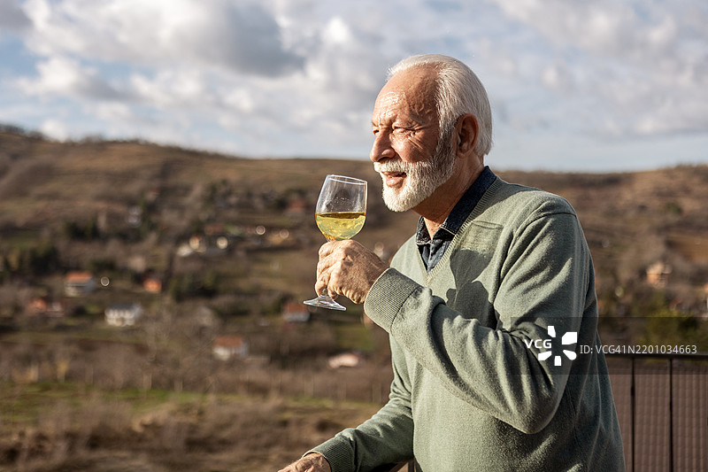 成熟男性在阳台上享受饮品图片素材