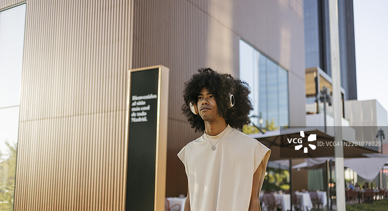 年轻男子通过蓝牙耳机听音乐图片素材