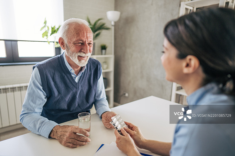 医生在家中给老年人服药图片素材