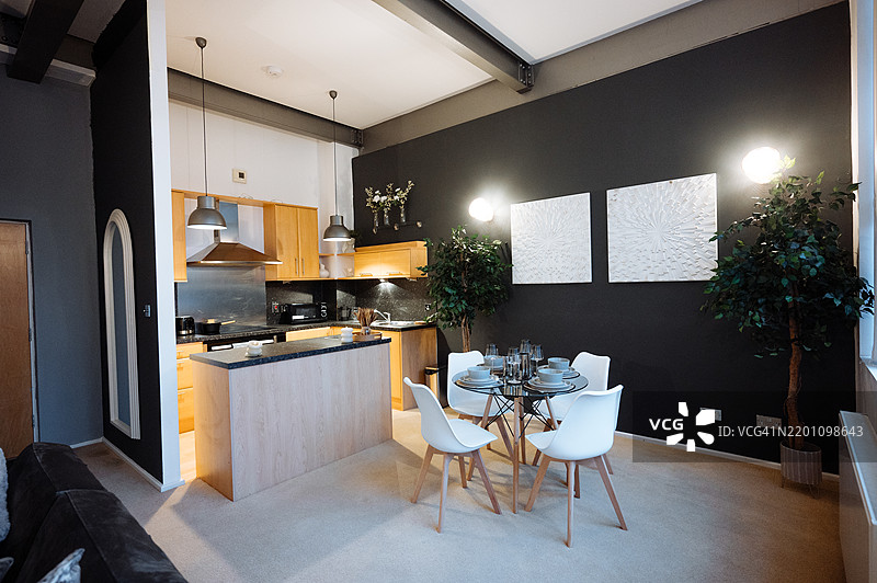 现代开放式厨房和餐厅，配有时尚家具和现代装饰，采用中性色调和室内植物。图片素材