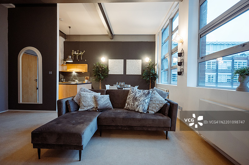 现代开放式厨房和餐厅，配有时尚家具和现代装饰，采用中性色调和室内植物。图片素材