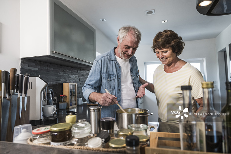 老年夫妇在家厨房里烹饪图片素材