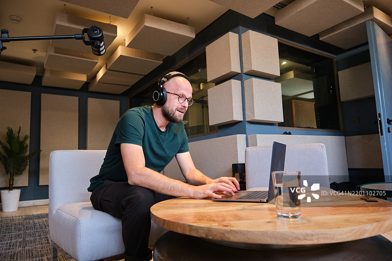 社交媒体影响者在工作室使用笔记本电脑图片素材