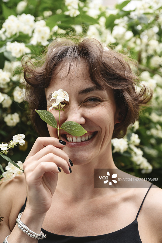 快乐的女人在花园里手捧茉莉花图片素材
