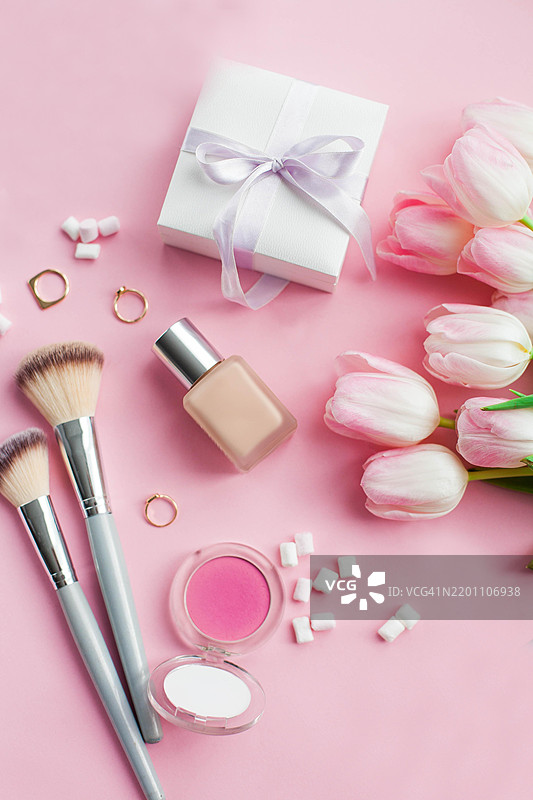 化妆品、装饰品、粉色背景上的郁金香花束。礼物。一盒礼物。国际妇女节。节日。春天。图片素材