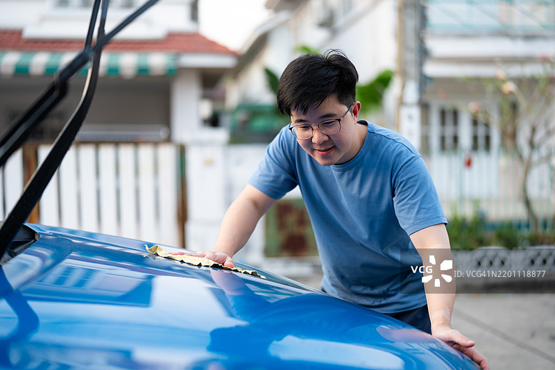 亚洲男子在家门口洗车图片素材