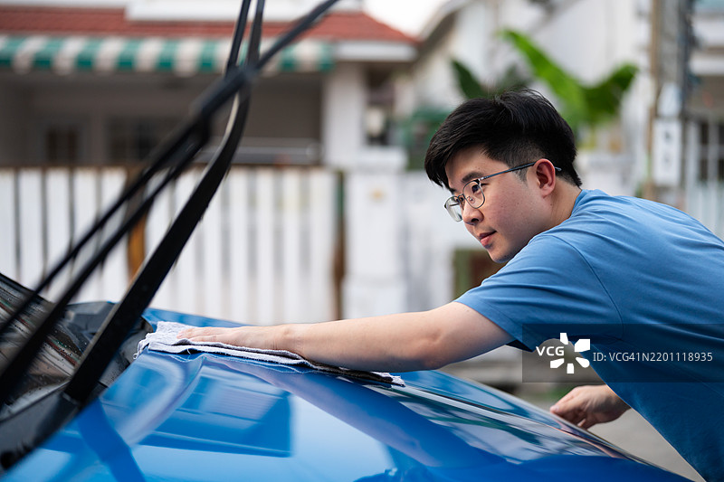 亚洲男子在家门口洗车图片素材
