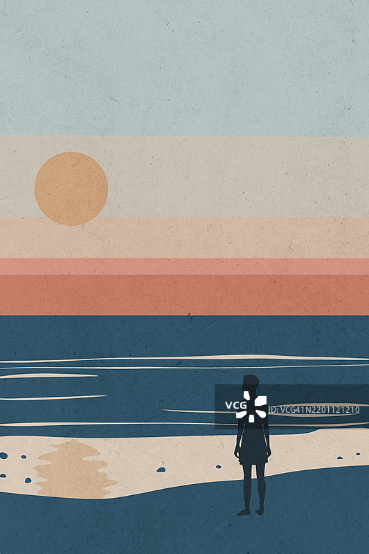 海滩上一个女人的剪影，凝视着海洋上美丽的日落图片素材