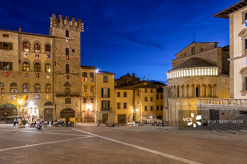 阿雷佐，托斯卡纳，意大利的广场大教堂与圣玛丽亚·德拉·皮耶韦教堂和兄弟会宫殿在黄昏时分的蓝天下。图片素材