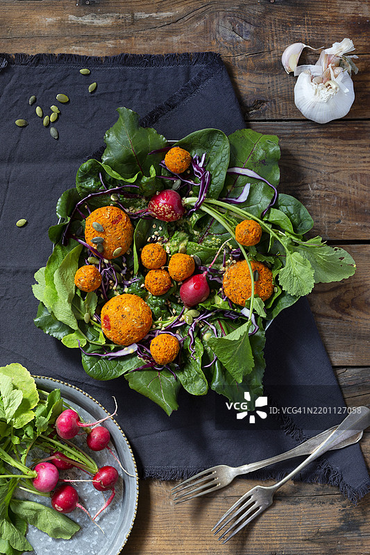 桌子上的扁豆肉丸配生菜和萝卜图片素材