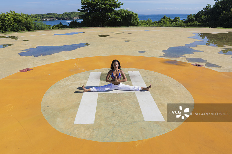 瑜伽教练在阳光明媚的公园里做劈叉图片素材