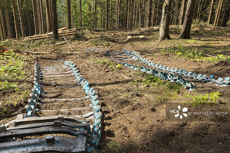 收割机的链条在森林地面上，德国萨克森州波卡乌-伦格费尔德附近的收获森林图片素材