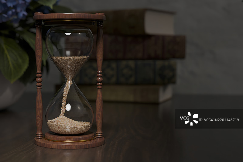桌子上的木质沙漏，背景有书籍图片素材