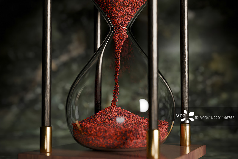 红色沙子沙漏的特写，配有木质底座和黑色框架图片素材