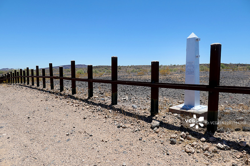 美国和墨西哥边界，国际边界标志和位于亚利桑那州卡贝萨·普里埃塔国家野生动物保护区的围栏（墙）在索诺兰沙漠中。图片素材