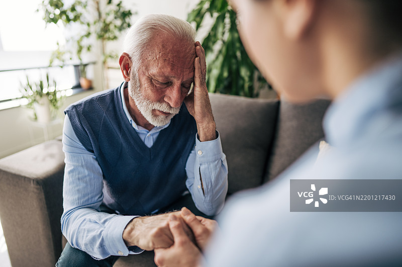 一位年长男性与他的治疗师交谈，正在经历抑郁。图片素材