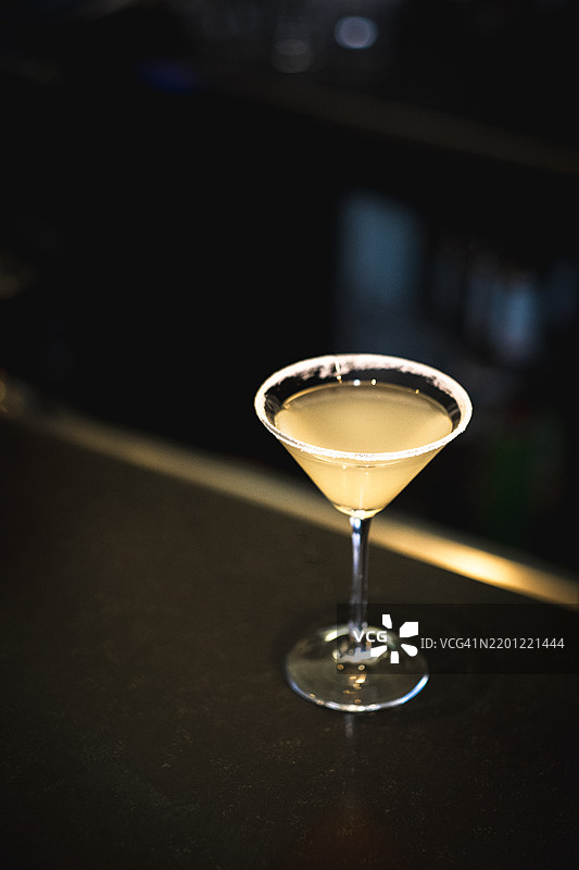 经典玛格丽塔鸡尾酒，糖边马提尼酒杯，清爽的夏季饮品，模糊的自然户外背景，优雅的调酒和鸡尾酒文化概念图片素材